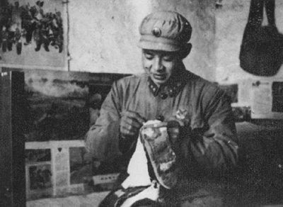 老照片：雷鋒在縫補自己的襪子