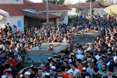 Jewish settlers gather around two army jeeps as the pray during a massive prayer held in front of the synagogue of the Jewish settlement of Neve Dekalim in the Gush Katif bloc of settlements in Gaza Strip (news - web sites) Thursday March 17, 2005. The prayer was part of a demonstration against Israel's planned withdrawal from the Gaza Strip and part of the West Bank. (AP Photo/Tsafrir Abayov) 