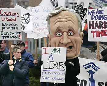 A protestor looks out from the mouth of giant effigy of Canadian Prime Minister Paul Martin during a demonstration in Kelowna, British Columbia November 24, 2005. About 50 Correctional Officers on strike protested outside the site where Martin and the provincial premiers were meeting with native leaders on Thursday.
