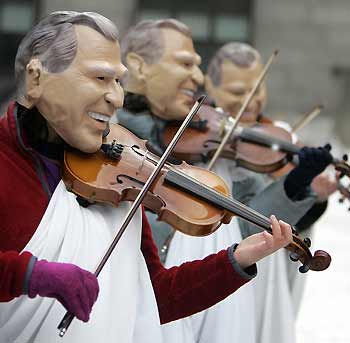 Demonstrators from the Environmental group Energy Action wearing masks depicting U.S. president George Bush fiddle outside the United Nations Climate Change Conference in Montreal December 5, 2005. The group depicted Bush as Emperor Nero fiddling while the planet burned. The group called on the U.S. to rejoin the Kyoto Protocol and said that the country's administration was out-of-touch with its citizens.