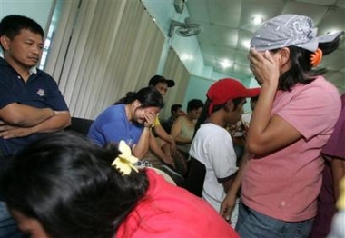 Relatives cry as they identify their loved ones among those who died during a stampede in suburban Pasig, east of Manila, Saturday, Feb. 4, 2006.
