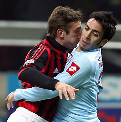 AC Milan's Andriy Shevchenko challenges Herman Paolo Dellafiore (R) of Treviso during their Italian Serie A soccer match at the San Siro Stadium in Milan, Italy February 8, 2006.
