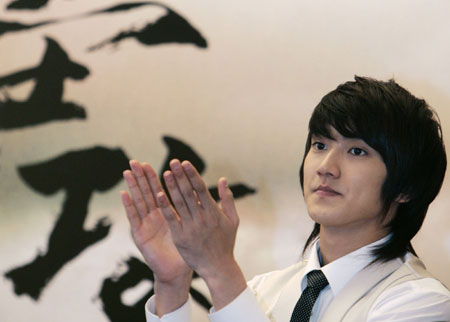 South Korean actor Choi Si Won applauds as he attends a news conference on his latest movie